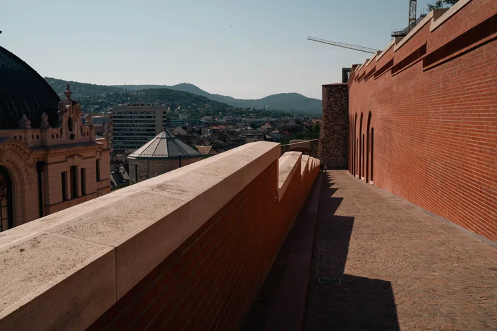 A brick wall and walkway above a hillside town