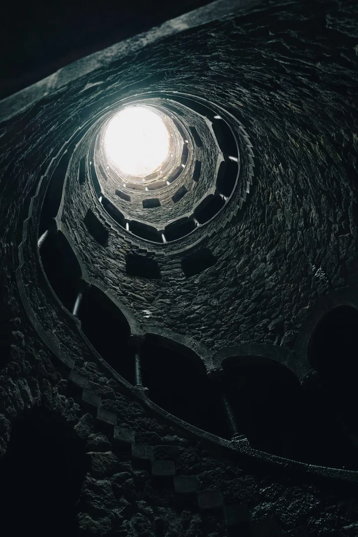 Looking up a spiral stone well toward the light