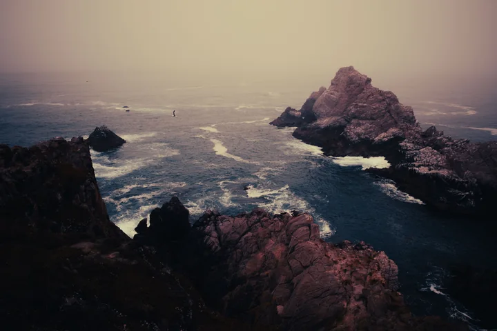 Rocky coastline under a hazy sky